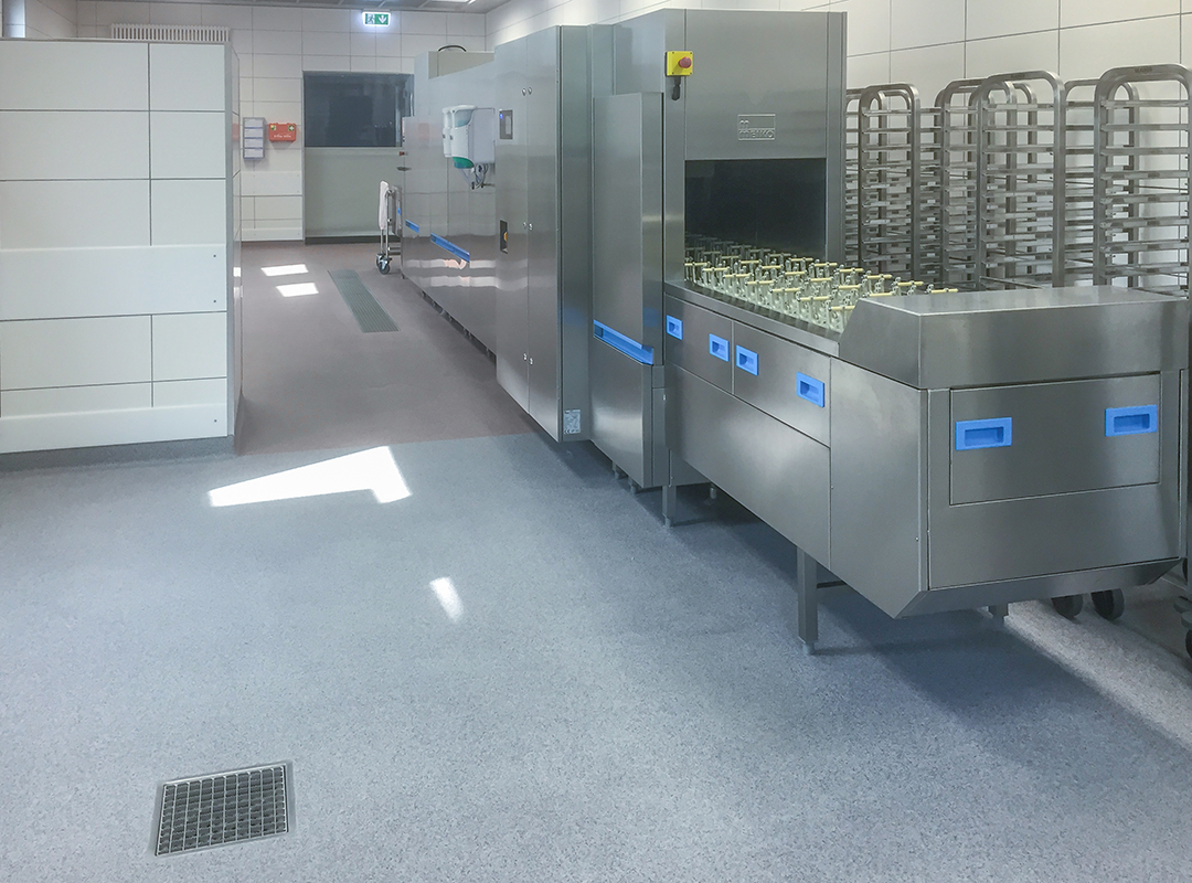 Waschstraße in einer Großküche mit Gläsern auf Reaktionsharzboden