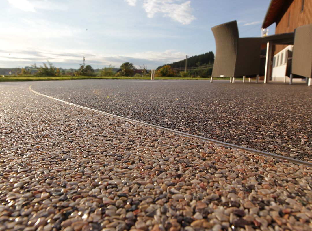 Steinteppich auf einer Terrasse mit Brunnen und einer Sitzecke